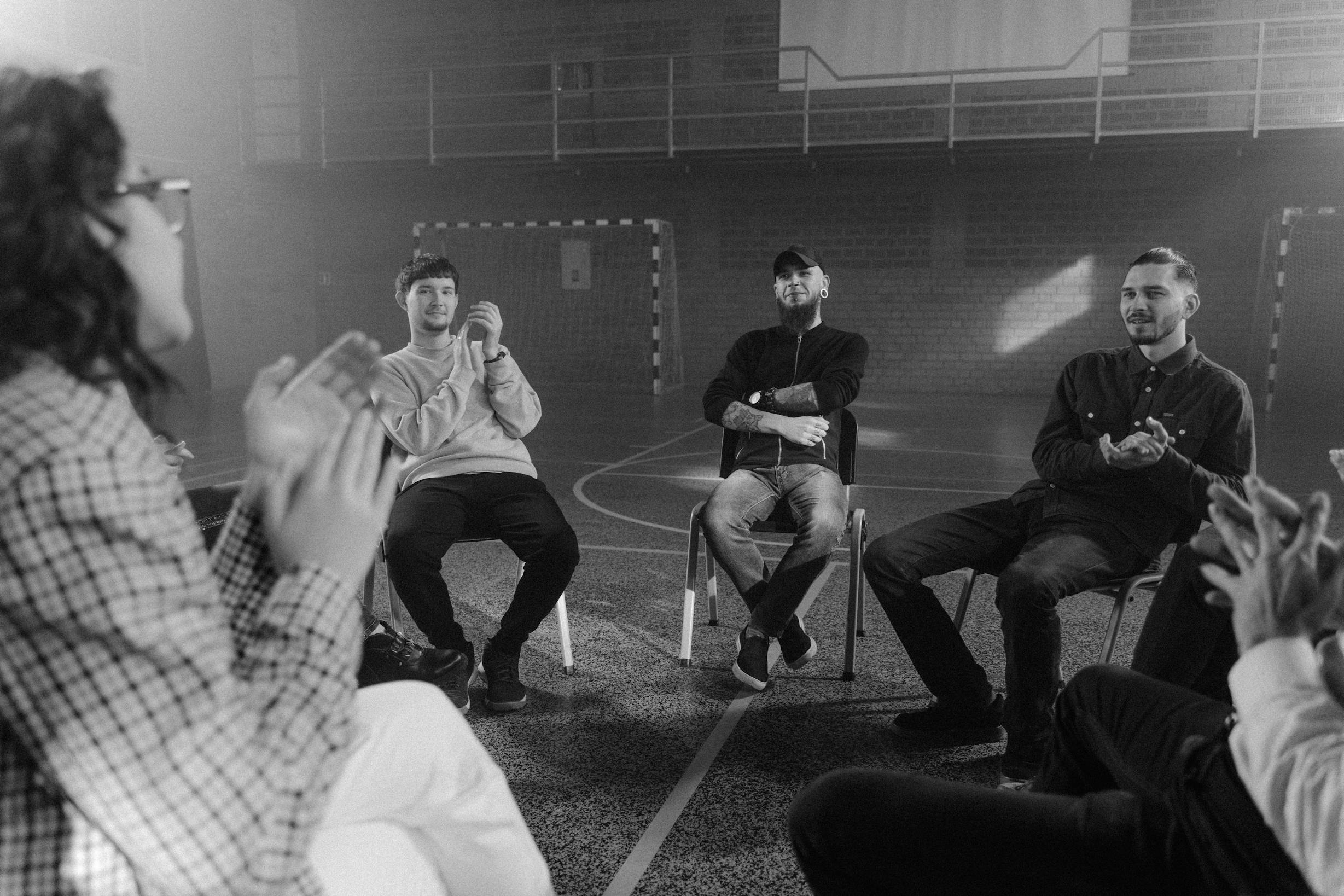A black and white image of a support group engaged in a therapy session.